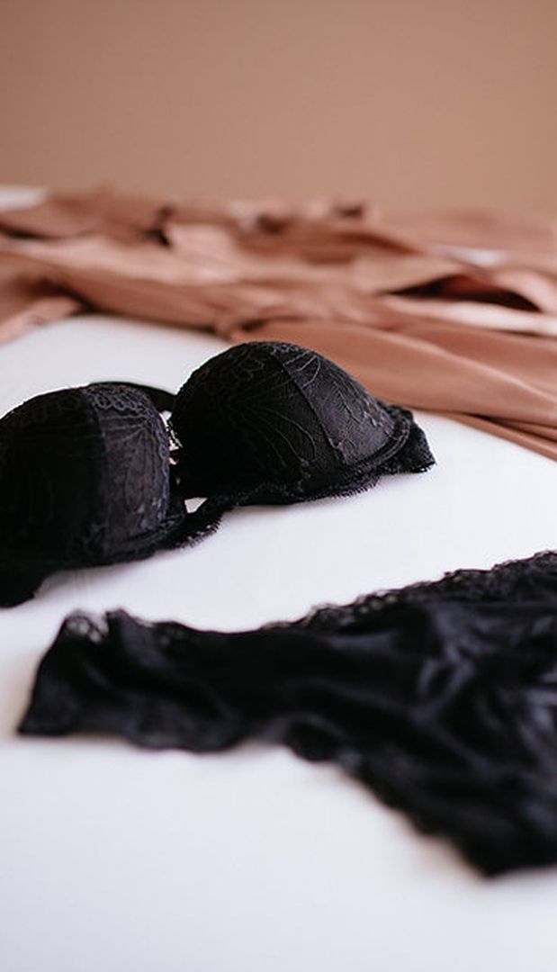 Schwarzes Spitzen-Dessous-Set auf Bett